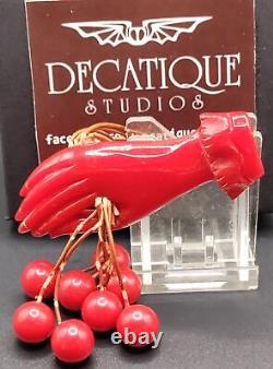 Red Bakelite Hand Holding 8 Dangling Beads Cherries Brooch