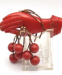 Red Bakelite Hand Holding 8 Dangling Beads Cherries Brooch