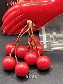 Red Bakelite Hand Holding 8 Dangling Beads Cherries Brooch